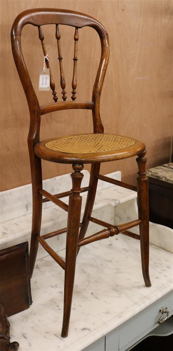 A childs fruitwood correction chair, with three turned spindles to the open waisted back, on turned legs and stretchers with